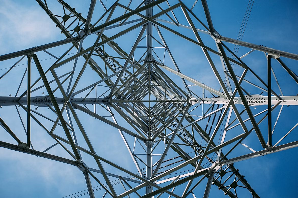 Looking up through a transmission tower's lattice