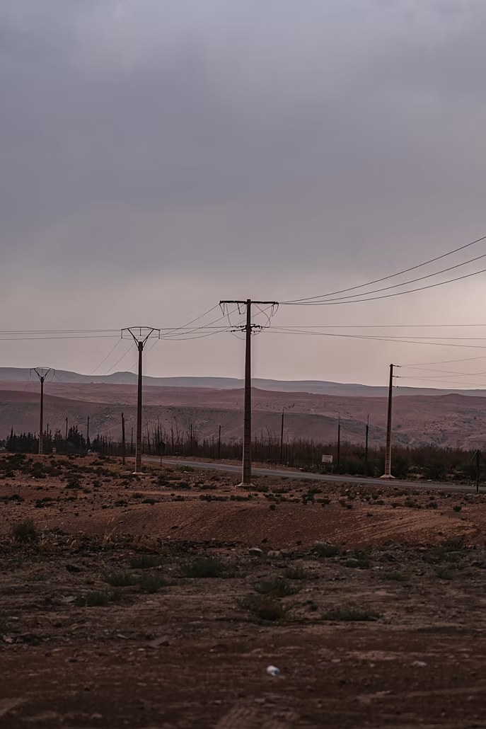 Utility poles and transmission lines across a desert landscape